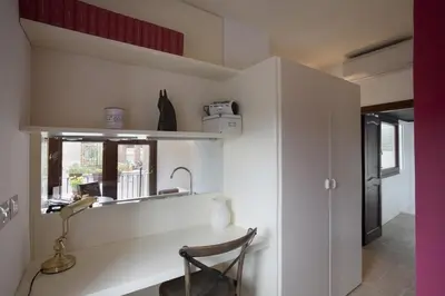 a kitchen with a table and a chair in a room at Laurina F2 roof terrace - LOCAPPART in Rome