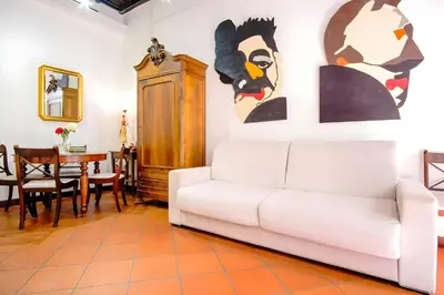 a living room with a white couch and paintings on the wall at Elegantis Eat Pray and Love in Rome - Near Navona Square and Campo de' Fiori in Rome