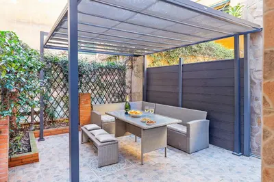 a patio with a table and chairs under a pergola at Casina Roxy in Rome