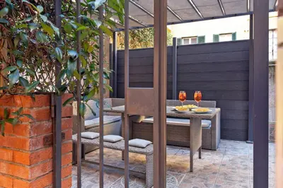 a patio with a table and chairs under a pergola at Casina Roxy in Rome