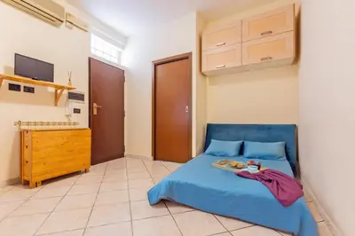 a bedroom with a blue bed and a tv at Casina Roxy in Rome