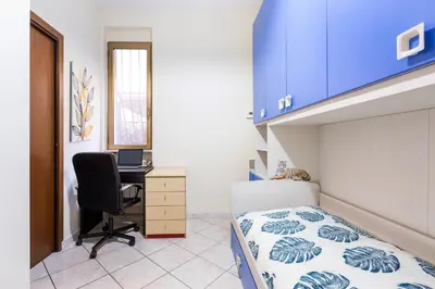 a bedroom with a bed and a desk with a computer at Casina Roxy in Rome