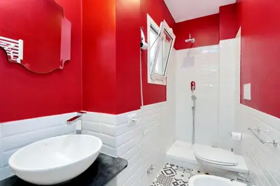 a red bathroom with two toilets and a sink at Monti Apartments - My Extra Home in Rome