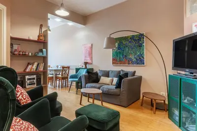 a living room with a couch and a tv at GuestHost - Cozy Ostiense Flat with Terrace! in Rome