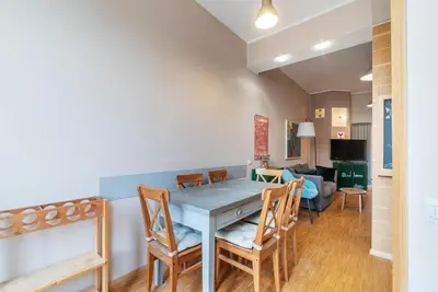 a dining room and living room with a table and chairs at GuestHost - Cozy Ostiense Flat with Terrace! in Rome