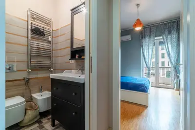 a bathroom with a sink and a toilet and a bed at GuestHost - Cozy Ostiense Flat with Terrace! in Rome