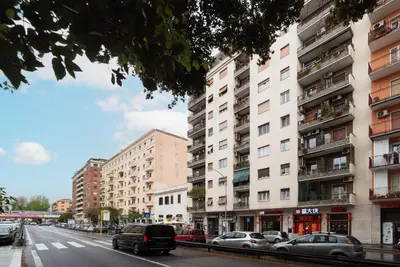 a city street with cars parked in front of tall buildings at GuestHost - Cozy Ostiense Flat with Terrace! in Rome