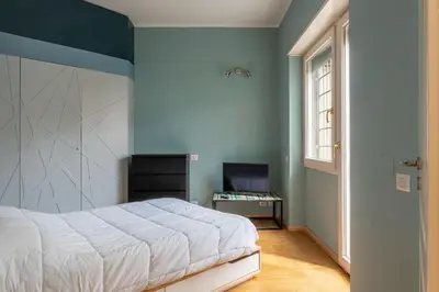 a bedroom with a white bed and a window at GuestHost - Cozy Ostiense Flat with Terrace! in Rome