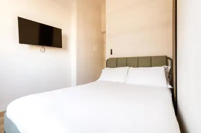 a bedroom with a bed with a flat screen tv on the wall at Cunabu Giolitti 12 in Rome