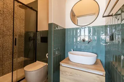 a bathroom with a sink and a toilet and a mirror at Cunabu Giolitti 12 in Rome