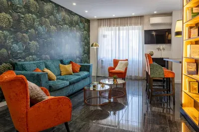 a living room with a blue couch and orange chairs at In Trastevere Luxury in Rome