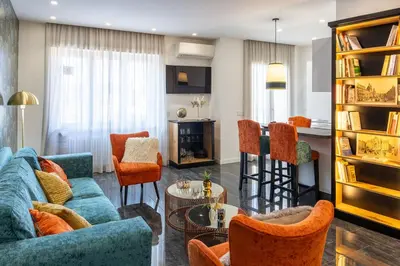 a living room with a blue couch and orange chairs at In Trastevere Luxury in Rome