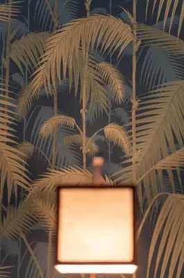 a laptop on a wall with a mural of palm trees at In Trastevere Luxury in Rome