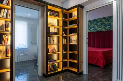 a room with a book shelf with books at In Trastevere Luxury in Rome