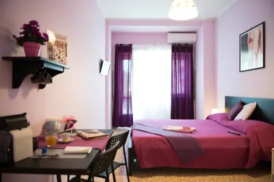 a bedroom with a purple bed and a table and a table and chairs at Authentic Sweet Home in Rome
