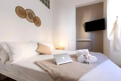 a white bed with a laptop on top of it at Trastevere 2Rooms with Balcony in Rome