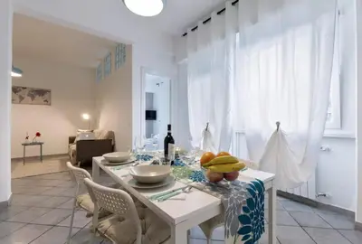 a white dining room with a table and chairs at Trastevere 2Rooms with Balcony in Rome