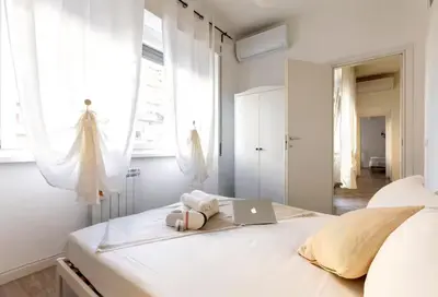 a bedroom with a bed with a laptop on it at Trastevere 2Rooms with Balcony in Rome
