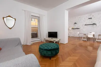 a living room with a couch and a table and a television at Fontana di Trevi Modern Apartment in Rome