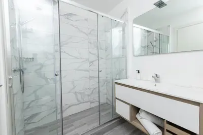 a bathroom with a glass shower and a sink at Fontana di Trevi Modern Apartment in Rome