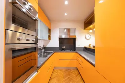 a kitchen with yellow cabinets and a stove at Fontana di Trevi Modern Apartment in Rome