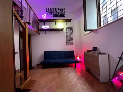 a living room with a blue couch and a staircase at Bnb cuore di Roma in Rome