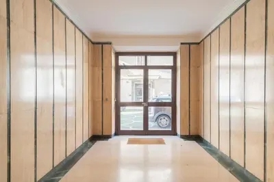 an empty hallway with a door and a window at MV Vatican House in Rome in Rome
