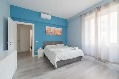 a blue bedroom with a bed and a large window at MV Vatican House in Rome in Rome