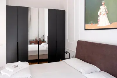 a bedroom with two beds and a mirror at Stunning 1BR, 2BATH Apartment in the Heart of Rome 6C in Rome