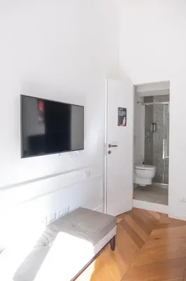 a white bathroom with a flat screen tv on a wall at Stunning 1BR, 2BATH Apartment in the Heart of Rome 6C in Rome