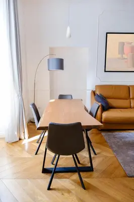 a table and chairs in a living room with a couch at Stunning 1BR, 2BATH Apartment in the Heart of Rome 6C in Rome