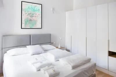 a bedroom with a white bed with two white pillows at Charming Vatican Apartment with Balcony 6B in Rome