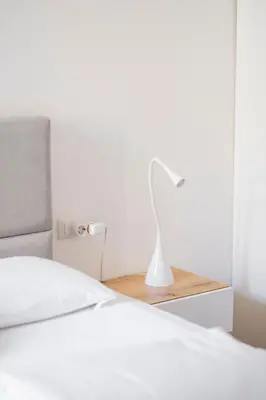 a white bed with a white lamp on a night stand at Charming Vatican Apartment with Balcony 6B in Rome