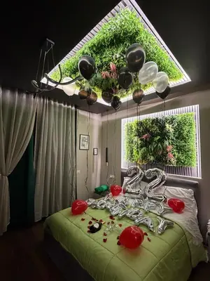 a bedroom with a green bed with a window with plants at La Dimora del Re in Rome