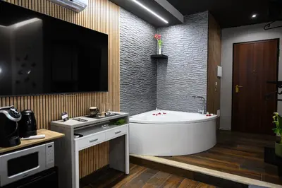 a bathroom with a tub and a sink and a tv at La Dimora del Re in Rome