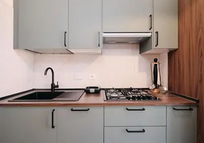 a kitchen with white cabinets and a sink and a stove at COLOSSEO a 15 min - Attico con Terrazza in Rome