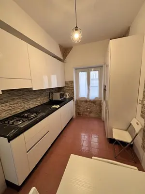 a kitchen with white cabinets and a stove top oven at Luca's House - Your perfect Roman hideaway in Rome