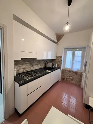 a kitchen with white cabinets and a stove at Luca's House - Your perfect Roman hideaway in Rome