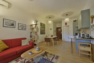 a living room with a red couch and a table at Joyful escape flat in Rome