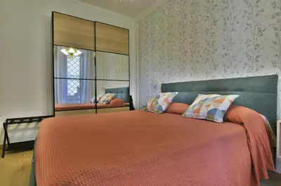 a bedroom with a large bed with orange sheets and a mirror at Joyful escape flat in Rome