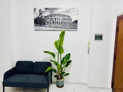 a blue couch and a plant in a room at Ayan Guest House in Rome