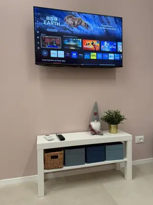 a tv hanging on a wall with a white table at Apartmentdigioia in Rome