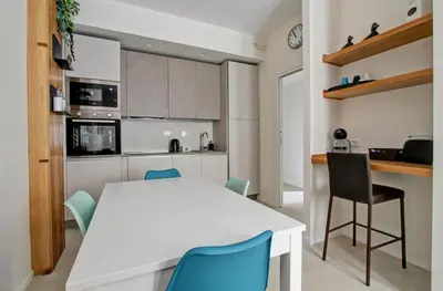 a kitchen with a white table and blue chairs at Apartmentdigioia in Rome