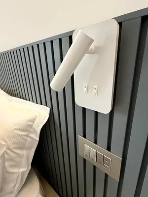 a light attached to a headboard of a bed at Aurelia Luxury Rome in Rome
