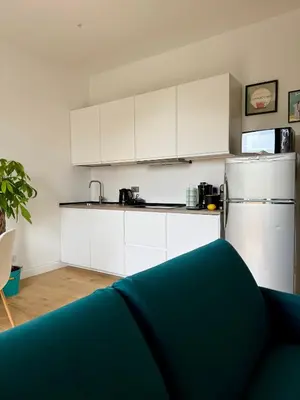 a kitchen with white cabinets and a white refrigerator at Aurelia Luxury Rome in Rome
