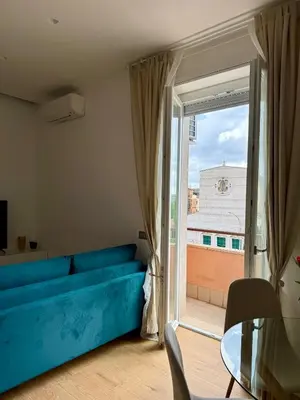 a living room with a blue couch and a large window at Aurelia Luxury Rome in Rome