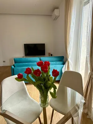 a living room with a vase of red roses on a table at Aurelia Luxury Rome in Rome