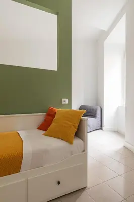 a bedroom with a bed with orange and yellow pillows at Glory House Trastevere 2 in Rome