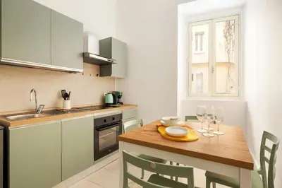 a kitchen with a wooden table with wine glasses on it at Glory House Trastevere 2 in Rome