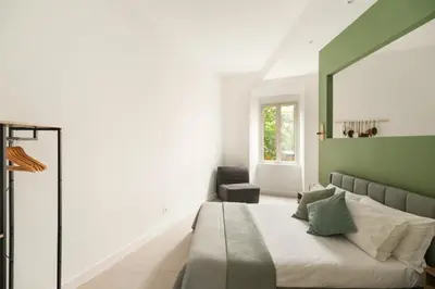 a bedroom with a bed with a green headboard at Glory House Trastevere 2 in Rome